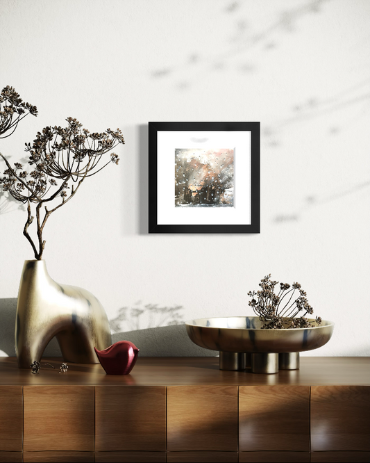 Decorative setup with a gold vase, red object, and framed atmospheric picture of a rainy scene with strong light and dark.